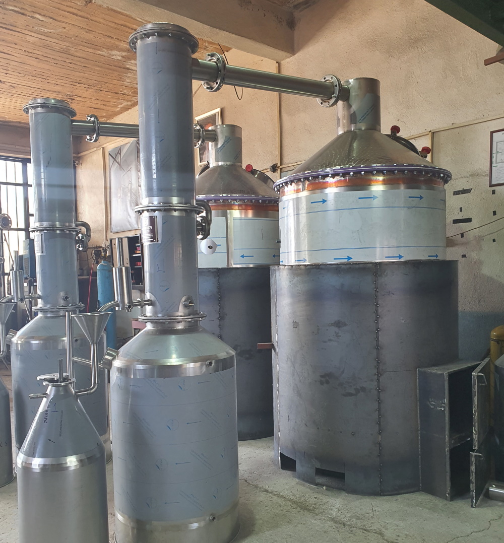 Stainless steel steam distillation stills with condensers in an essential oil production hall