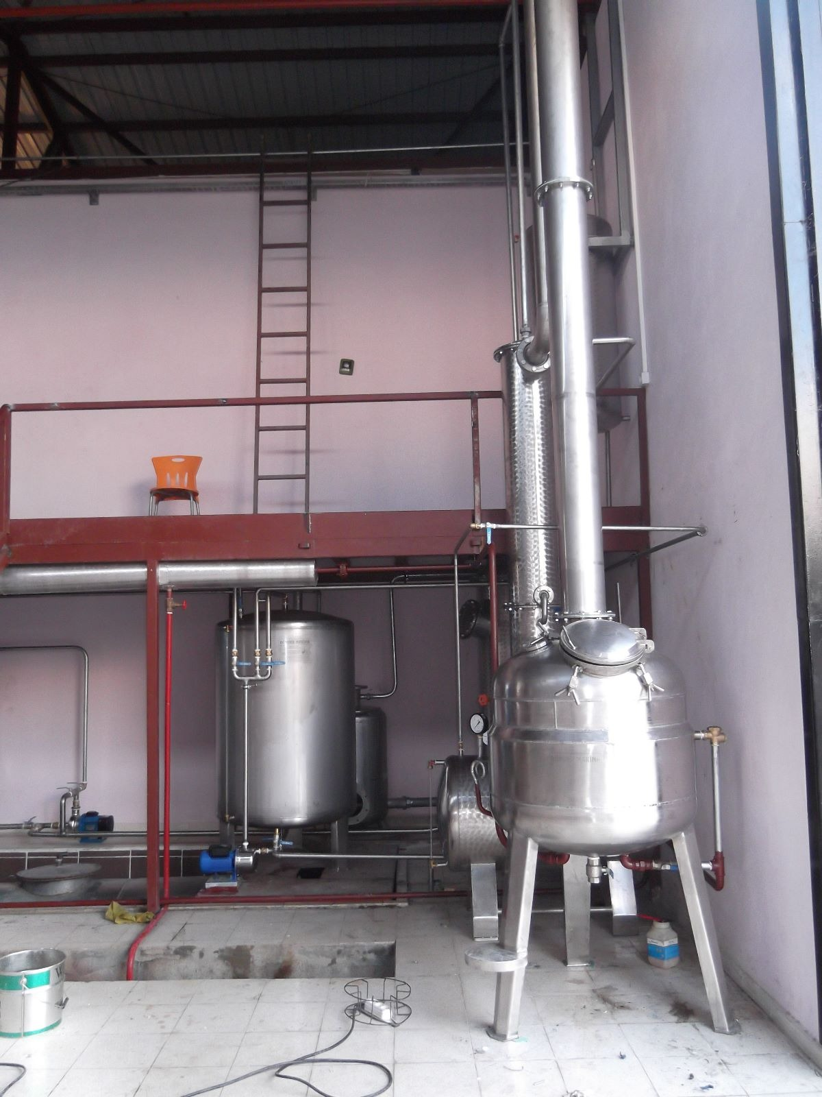 Tall stainless steel distillation column installed in a production plant