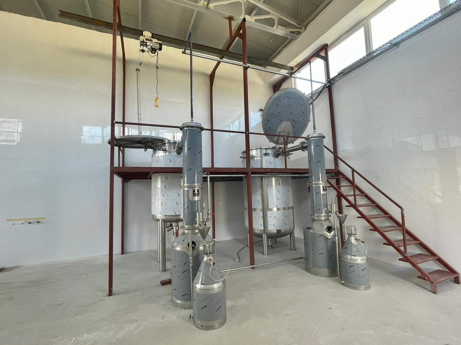 Stainless steel steam distillation unit with a red mezzanine platform