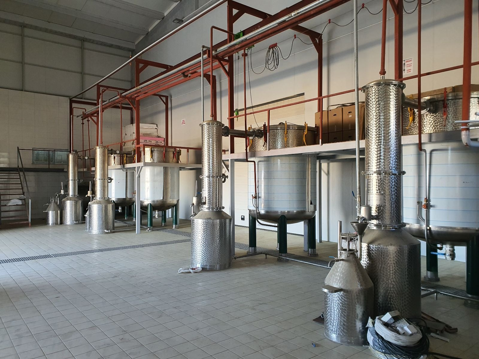 Essential oil distillation plant with red steel structure and stainless steel stills