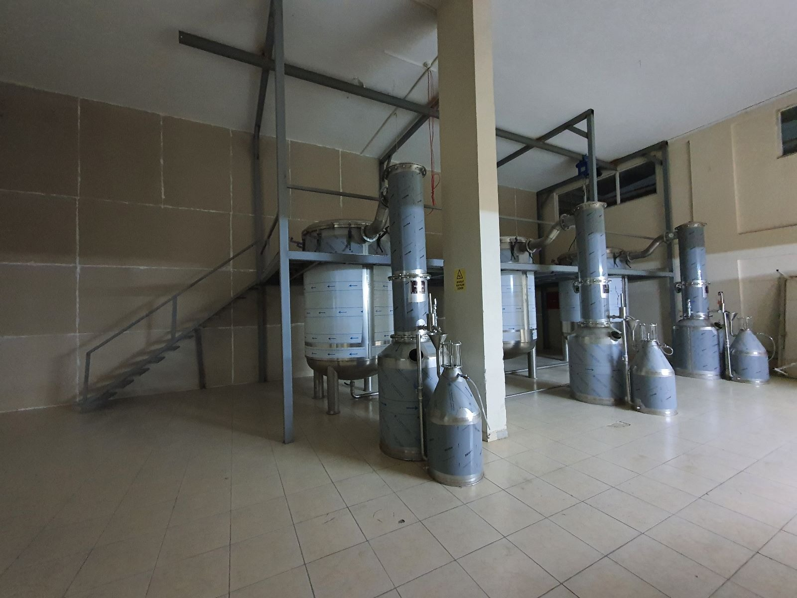 Steam and water distillation units with condensers in a production hall