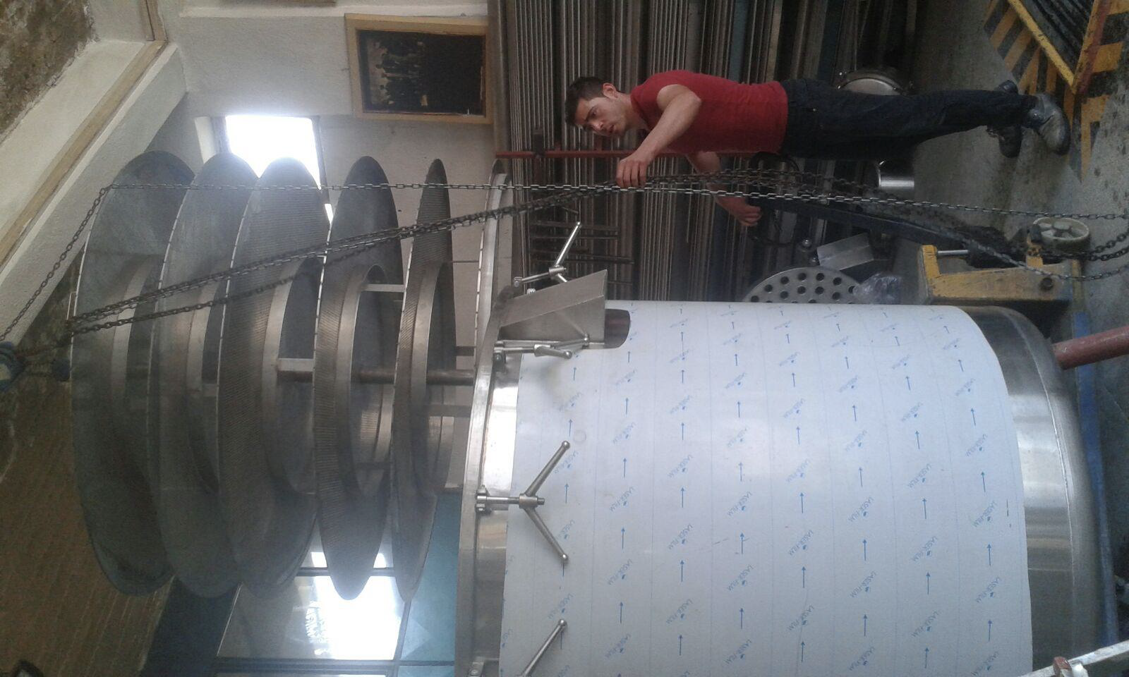 Perforated extractor basket being fitted into a stainless steel extraction vessel