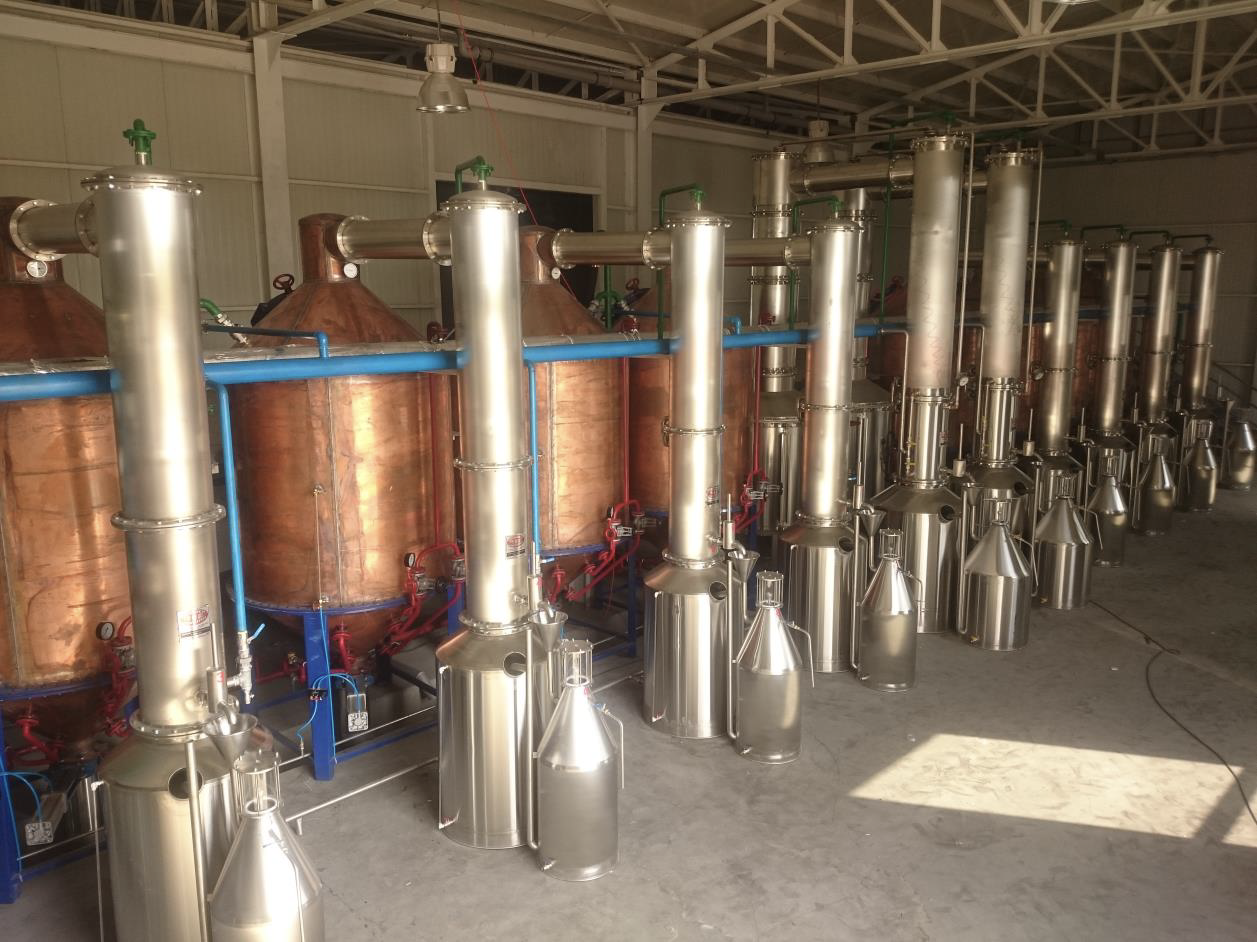 Row of copper stills with condensers in a rose oil distillery