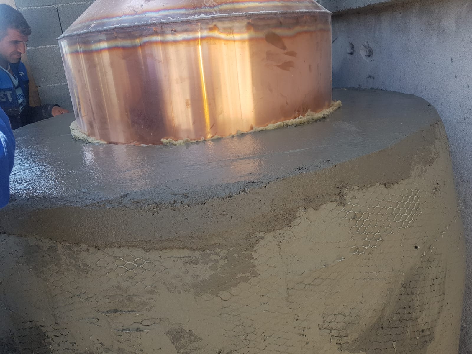 Copper rose still set into masonry for wood firing