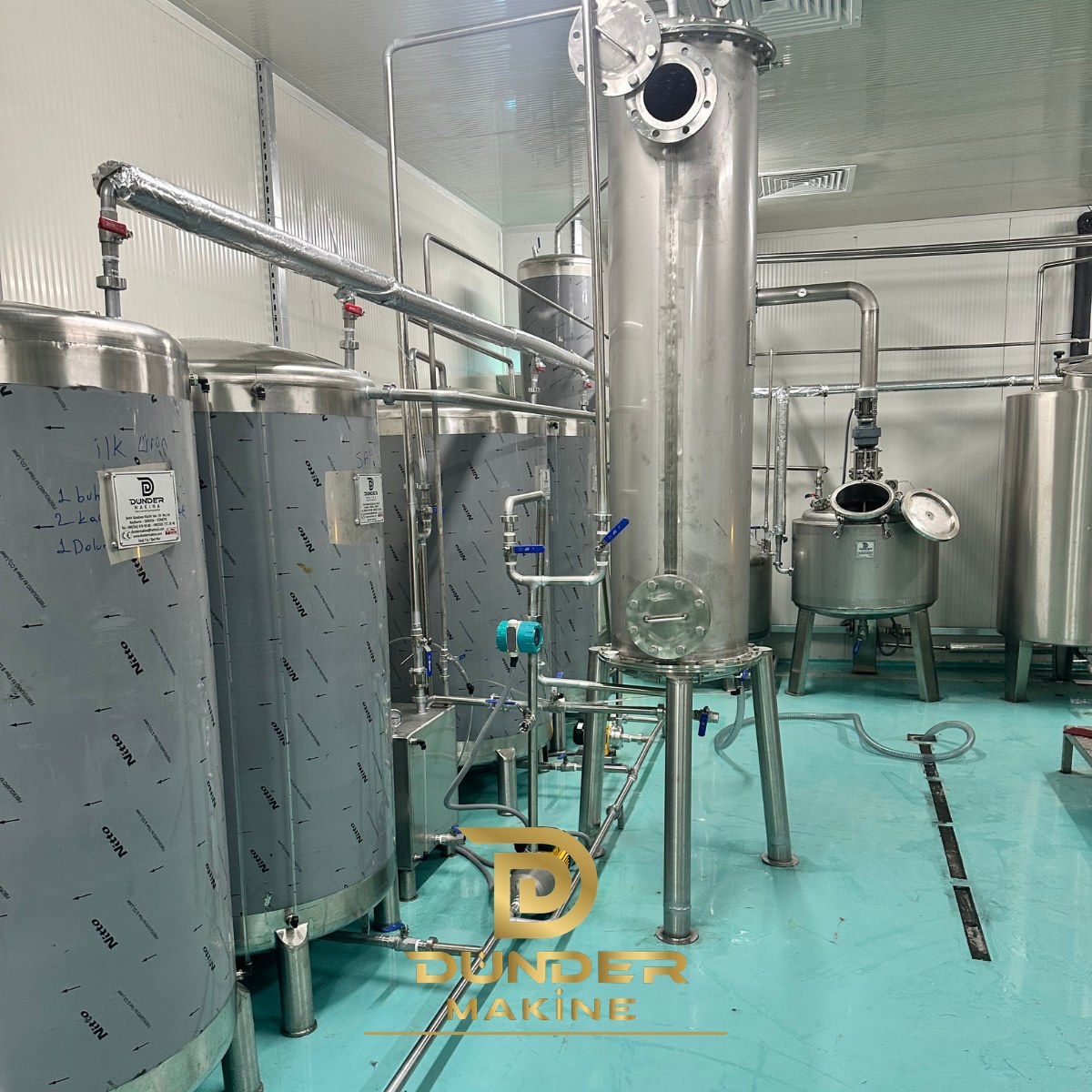 Stainless steel distillation column with product tanks and jacketed reactor in a clean production room