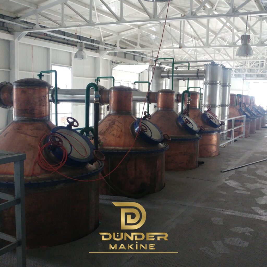 Rose oil plant with a long row of copper stills and stainless steel condensers by Dünder Makine
