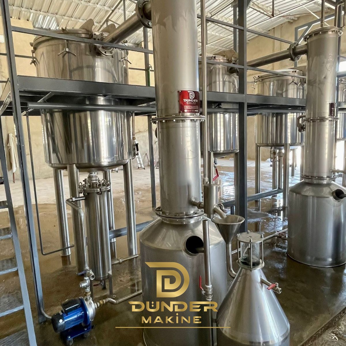 Bag filter and transfer pump next to stainless steel distillation units by Dünder Makine